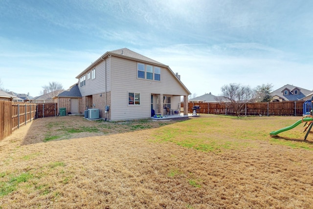 rear view of property featuring central AC, a patio, a lawn, and a playground