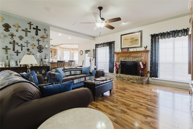 living room featuring a fireplace, ceiling fan, crown molding, and hardwood / wood-style floors