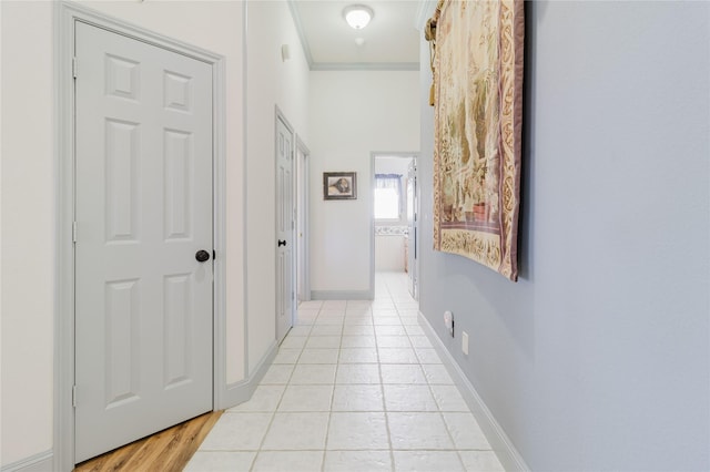 hallway with light tile patterned flooring and ornamental molding