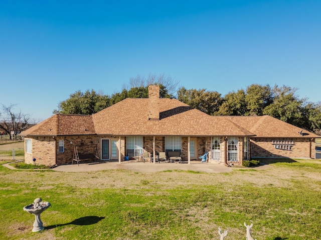 back of property with a yard and a patio area