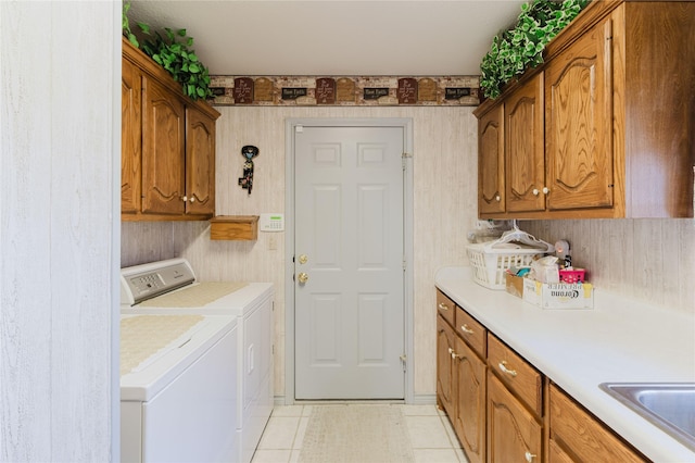 laundry room featuring washer and dryer, cabinets, sink, and light tile patterned flooring