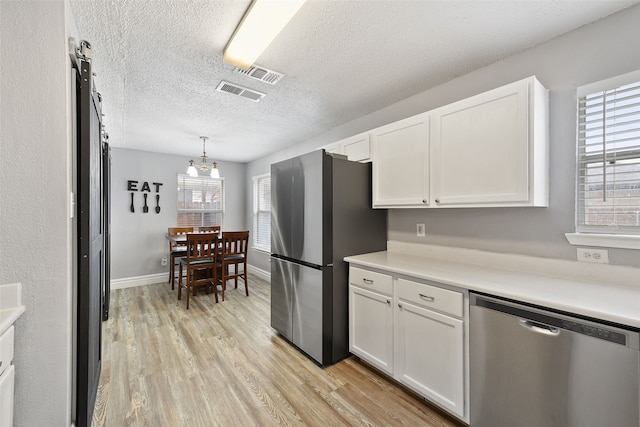 728 Oriole Dr, Saginaw, TX 76131 - kitchen featuring stainless steel appliances, light countertops, decorative light fixtures, and white cabinets