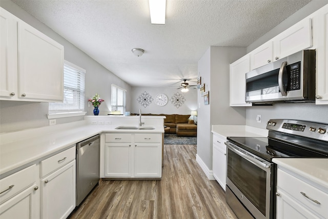 728 Oriole Dr, Saginaw, TX 76131 - kitchen with appliances with stainless steel finishes, light countertops, a sink, and white cabinetry