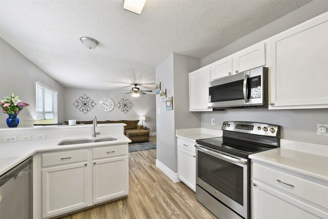 728 Oriole Dr, Saginaw, TX 76131 - kitchen with stainless steel appliances, light countertops, a sink, and white cabinetry