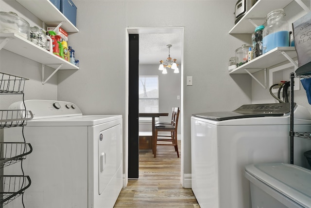 728 Oriole Dr, Saginaw, TX 76131 - laundry area with a textured ceiling, washing machine and dryer, baseboards, light wood-type flooring, and an inviting chandelier