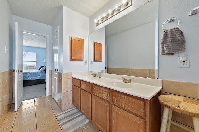 728 Oriole Dr, Saginaw, TX 76131 - bathroom featuring ensuite bathroom, a textured ceiling, tile patterned flooring, a sink, and double vanity