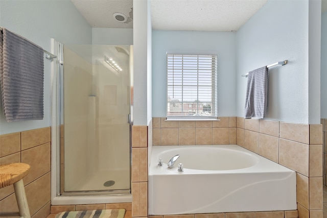 728 Oriole Dr, Saginaw, TX 76131 - bathroom featuring a bath, a shower stall, tile walls, and a textured ceiling