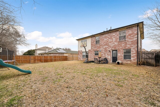 728 Oriole Dr, Saginaw, TX 76131 - rear view of property with brick siding, a trampoline, and a fenced backyard