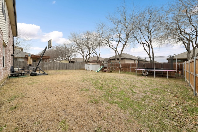 728 Oriole Dr, Saginaw, TX 76131 - view of yard with a playground, a fenced backyard, an outdoor structure, a storage unit, and a trampoline