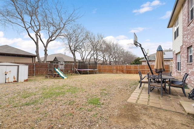 728 Oriole Dr, Saginaw, TX 76131 - view of yard featuring a playground, a fenced backyard, a storage shed, a trampoline, and a patio area