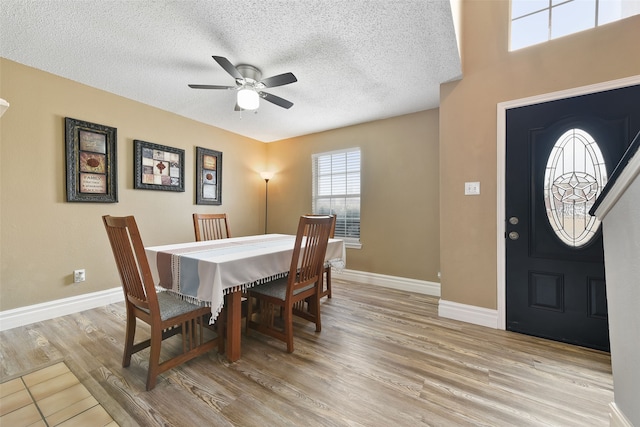 728 Oriole Dr, Saginaw, TX 76131 - dining room featuring light wood-type flooring, a ceiling fan, baseboards, and a textured ceiling