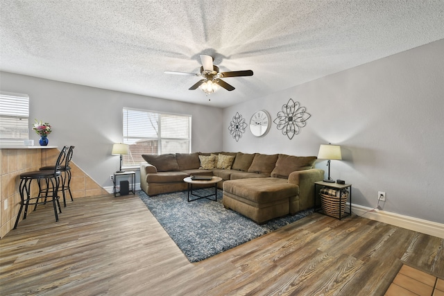 728 Oriole Dr, Saginaw, TX 76131 - living room featuring dark wood-style floors, a textured ceiling, and baseboards