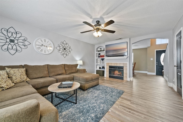 728 Oriole Dr, Saginaw, TX 76131 - living room with baseboards, a textured ceiling, arched walkways, and wood finished floors