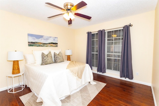 bedroom with ceiling fan, dark hardwood / wood-style floors, and a textured ceiling