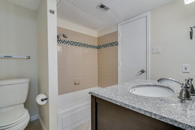 full bathroom featuring toilet, tiled shower / bath, a textured ceiling, vanity, and tile patterned flooring