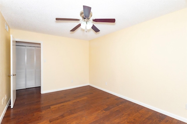 unfurnished bedroom featuring dark wood-type flooring and ceiling fan