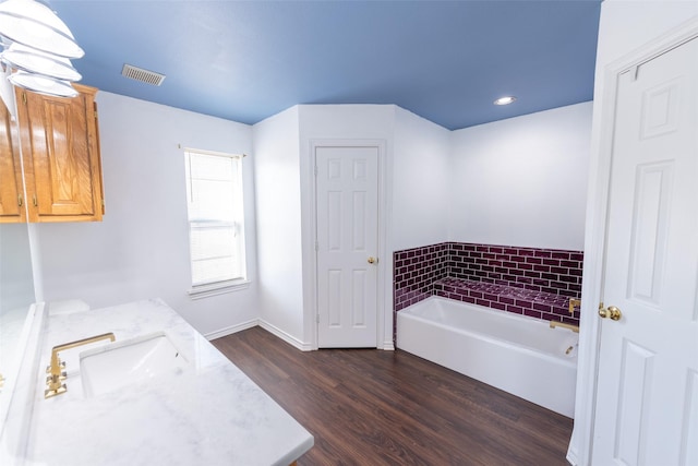 bathroom featuring vanity, hardwood / wood-style floors, and a bathtub