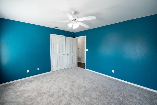 unfurnished bedroom with ceiling fan, carpet flooring, and a closet