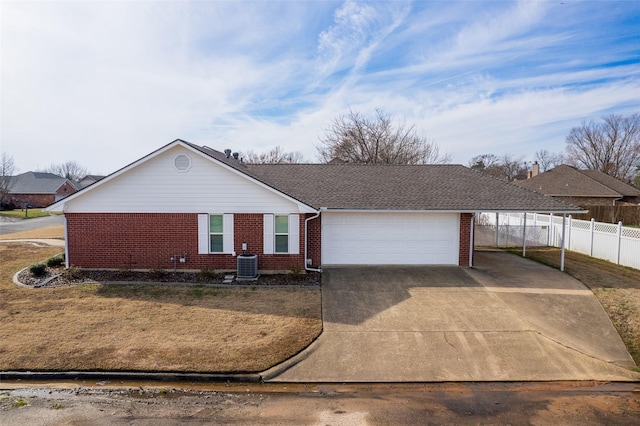 ranch-style home featuring a carport, a garage, central AC unit, and a front yard