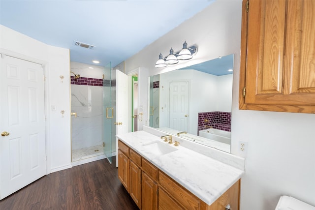 bathroom featuring independent shower and bath, wood-type flooring, and vanity