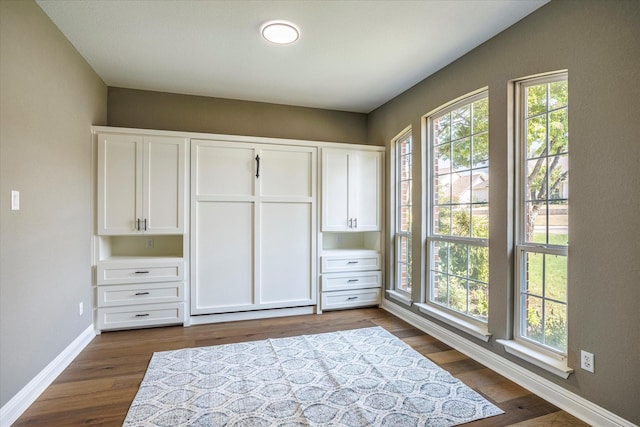 unfurnished bedroom with dark hardwood / wood-style flooring