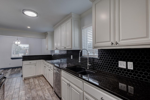 kitchen with sink, hanging light fixtures, appliances with stainless steel finishes, decorative backsplash, and white cabinets