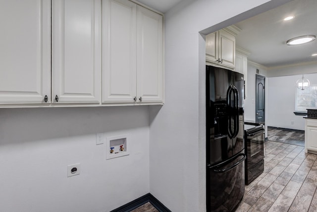 kitchen featuring white cabinetry, crown molding, light wood-type flooring, and black appliances