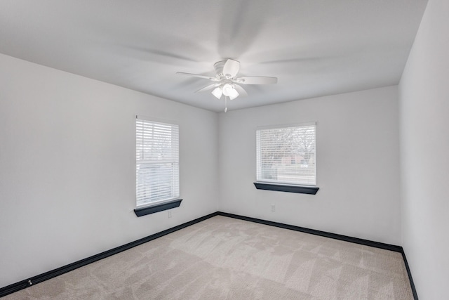 spare room with light colored carpet and ceiling fan