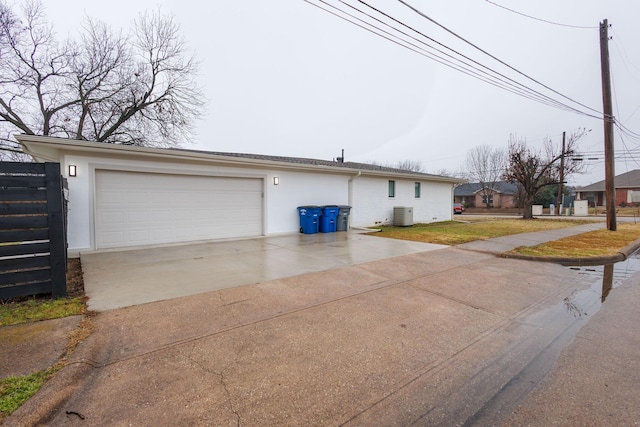 view of home's exterior with central AC unit and a garage