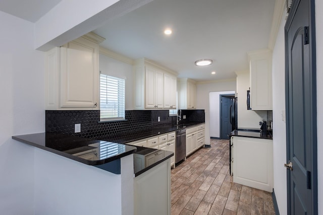 kitchen with tasteful backsplash, white cabinetry, sink, stainless steel dishwasher, and kitchen peninsula