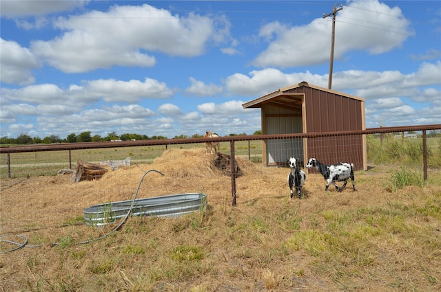 view of yard featuring a rural view and an outdoor structure