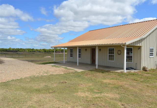 rear view of house with a lawn and a patio