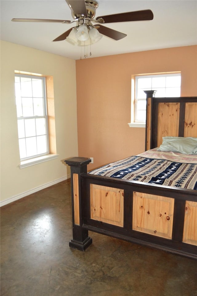 bedroom featuring baseboards, a ceiling fan, and finished concrete floors
