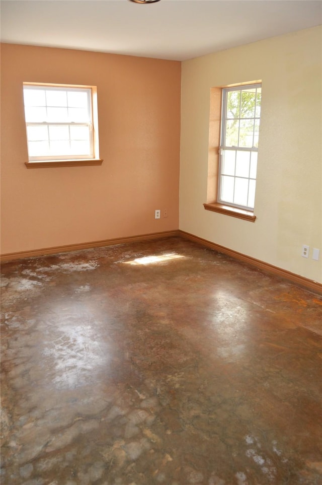 unfurnished room with concrete flooring and baseboards