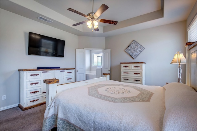 carpeted bedroom featuring ceiling fan and a raised ceiling