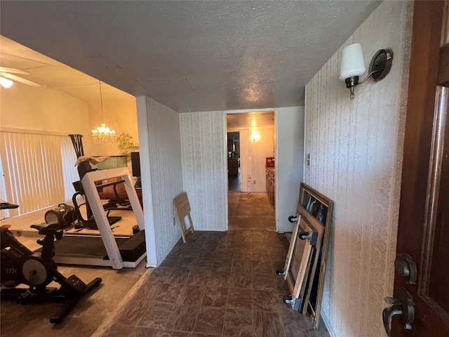 exercise area featuring a chandelier and a textured ceiling