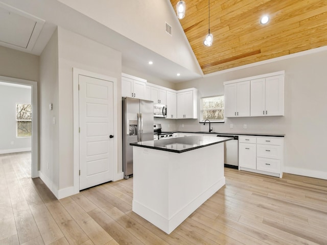 kitchen with pendant lighting, white cabinetry, sink, a center island, and stainless steel appliances