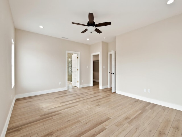 spare room with ceiling fan and light wood-type flooring