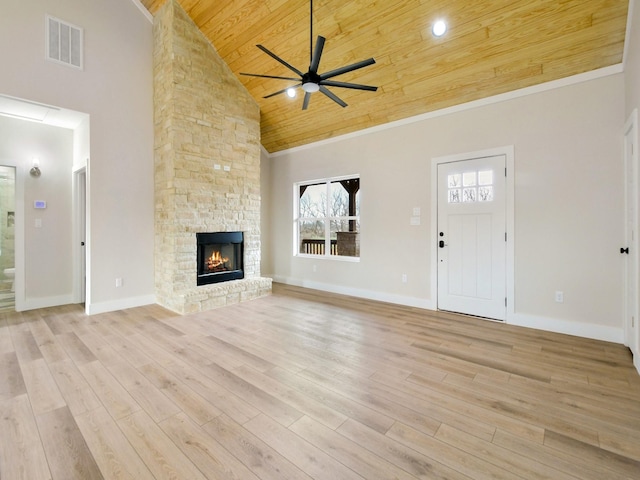 unfurnished living room featuring a stone fireplace, high vaulted ceiling, light hardwood / wood-style flooring, and wooden ceiling