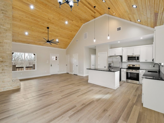 kitchen with pendant lighting, sink, white cabinetry, stainless steel appliances, and high vaulted ceiling