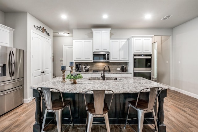 kitchen with white cabinetry, sink, a spacious island, and appliances with stainless steel finishes