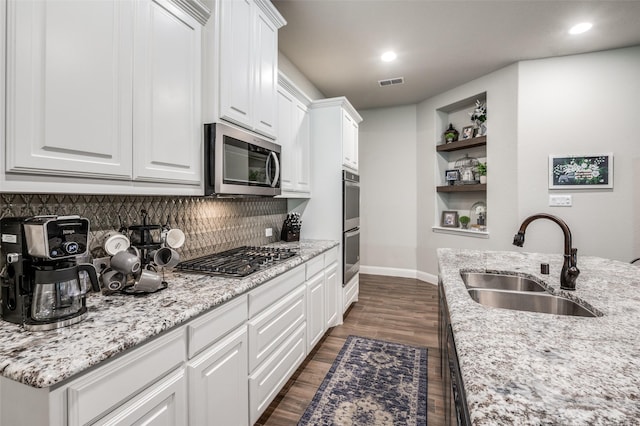 kitchen featuring stainless steel appliances, white cabinetry, and sink