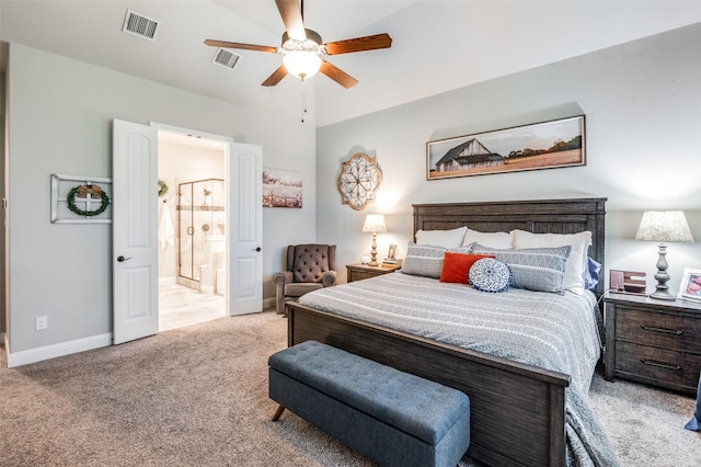 bedroom with ensuite bathroom, light colored carpet, and ceiling fan