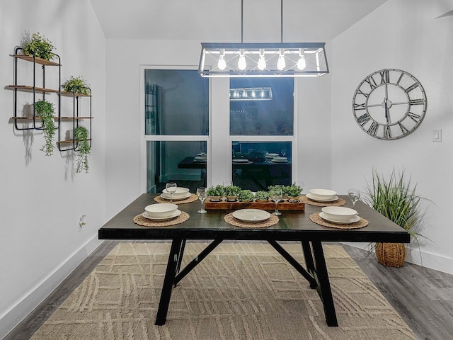 dining area featuring dark wood-type flooring and baseboards