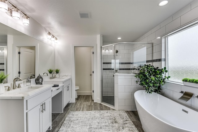 bathroom featuring two vanities, visible vents, a sink, and a shower stall