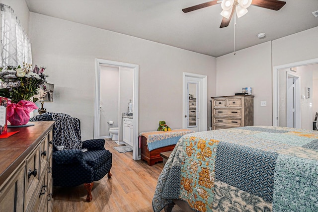 bedroom featuring visible vents, ensuite bath, light wood-style flooring, and a ceiling fan