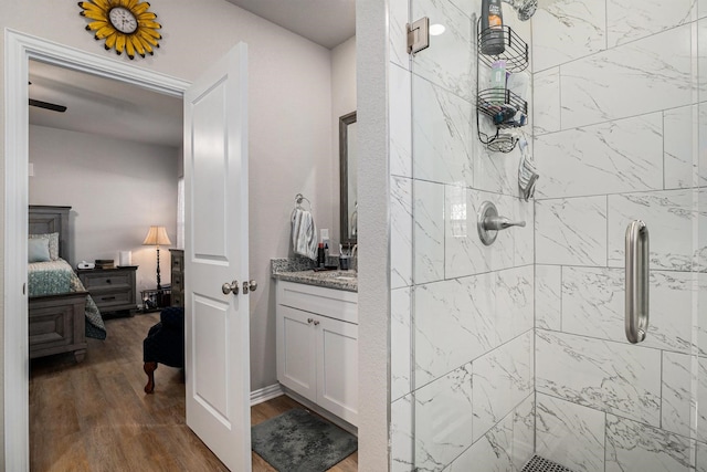 ensuite bathroom with a stall shower, wood finished floors, vanity, and connected bathroom