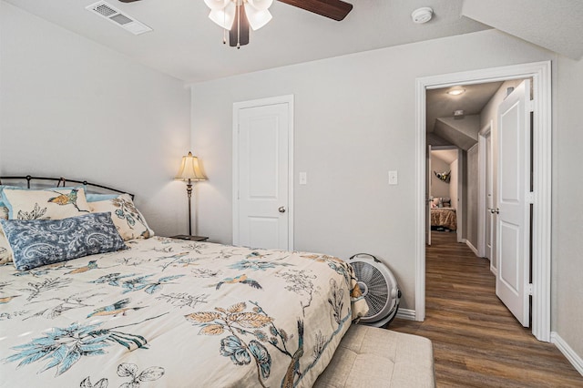 bedroom with ceiling fan, wood finished floors, visible vents, and baseboards