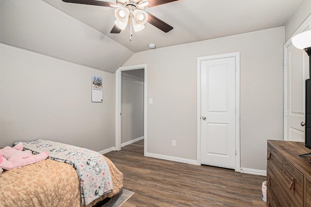 bedroom with a ceiling fan, dark wood-style flooring, vaulted ceiling, and baseboards