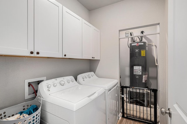 laundry area with wood finished floors, cabinet space, washer and clothes dryer, and water heater